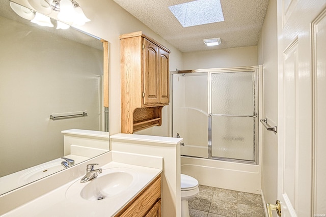 bathroom with vanity, toilet, a textured ceiling, enclosed tub / shower combo, and a skylight