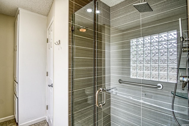 bathroom with a textured ceiling and a shower stall