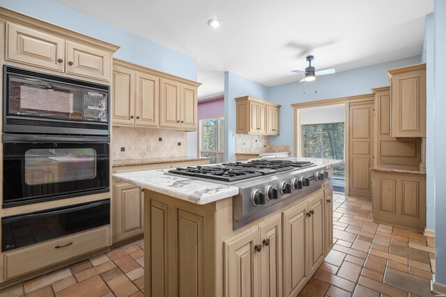 kitchen with stone tile flooring, black appliances, backsplash, and a warming drawer