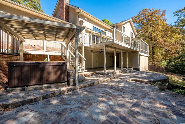 view of property exterior featuring a patio, a chimney, stairway, a hot tub, and fence