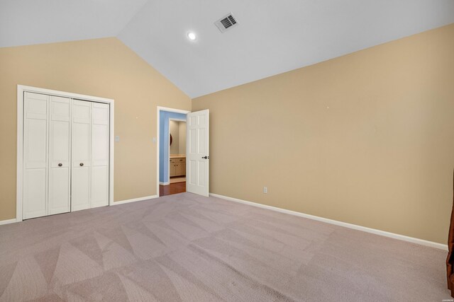 unfurnished bedroom featuring lofted ceiling, baseboards, visible vents, and carpet flooring