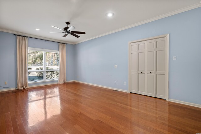 interior space featuring recessed lighting, wood finished floors, a ceiling fan, baseboards, and crown molding