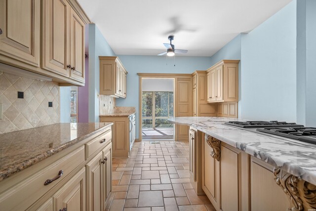 kitchen featuring tasteful backsplash, ceiling fan, light stone counters, stone finish flooring, and light brown cabinetry