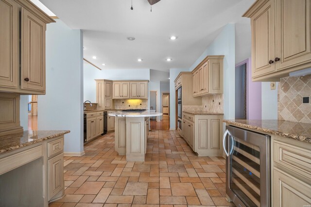 kitchen with light stone countertops, wine cooler, backsplash, and cream cabinetry