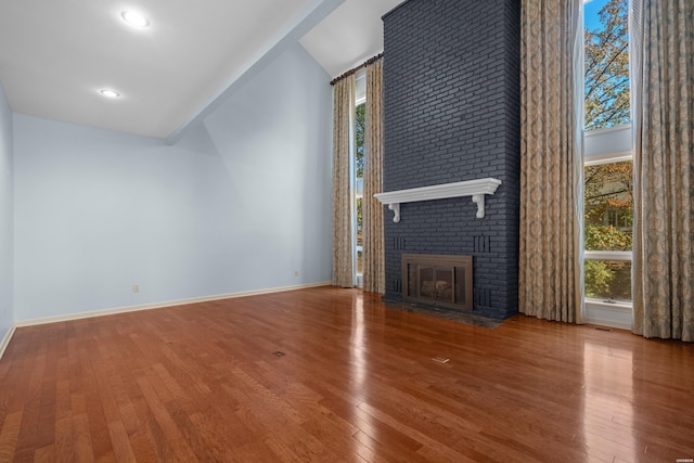 unfurnished living room featuring hardwood / wood-style flooring, a fireplace, and baseboards