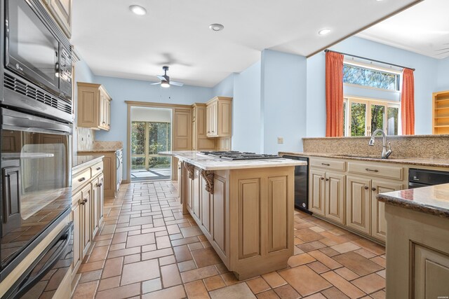 kitchen with dishwasher, a kitchen island, cream cabinetry, black microwave, and a sink