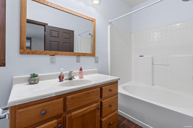 bathroom featuring shower / washtub combination, vanity, and wood finished floors