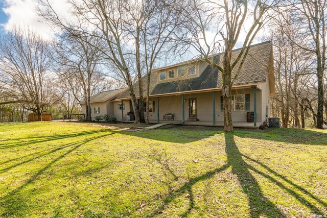 view of front of home with roof with shingles and a front yard