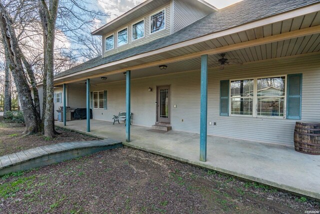 exterior space featuring a shingled roof, a patio, and ceiling fan