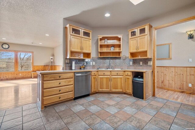 kitchen featuring a sink, light countertops, wainscoting, dishwasher, and open shelves