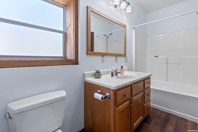 bathroom with vanity, shower / bath combination, wood finished floors, and toilet