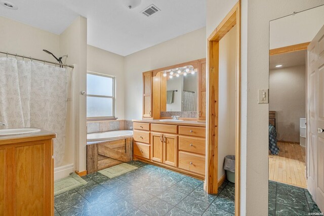 bathroom featuring curtained shower, visible vents, a garden tub, and vanity