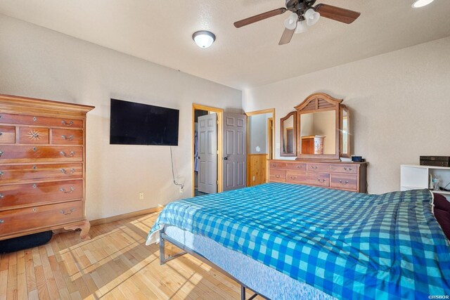 bedroom featuring baseboards, a ceiling fan, and wood finished floors