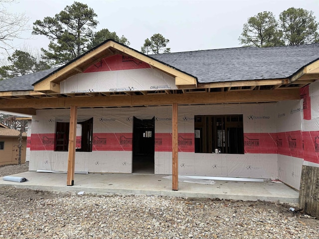 exterior space featuring roof with shingles