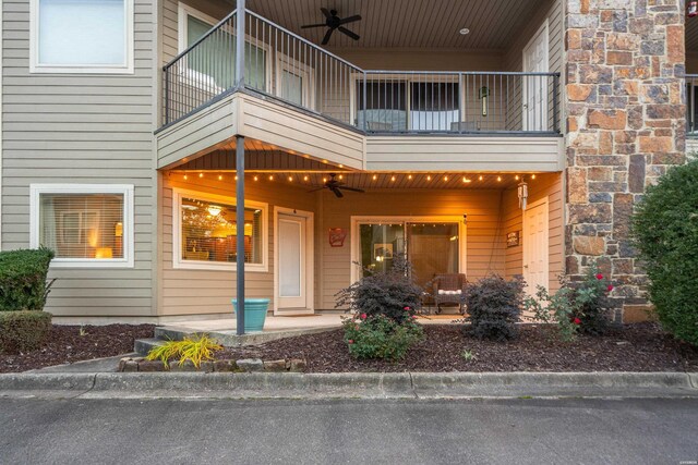 entrance to property featuring a balcony and a ceiling fan