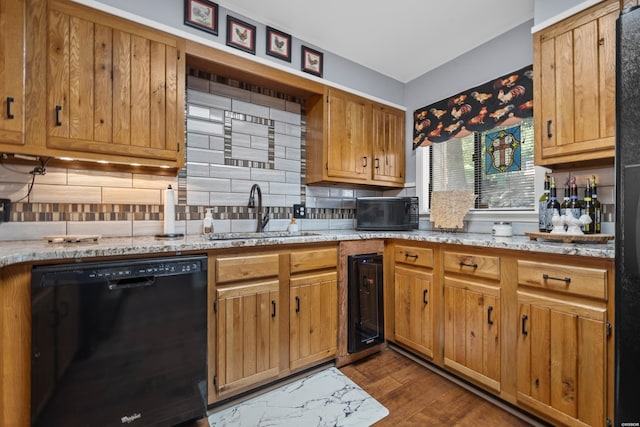 kitchen featuring brown cabinetry, dishwasher, a sink, and tasteful backsplash