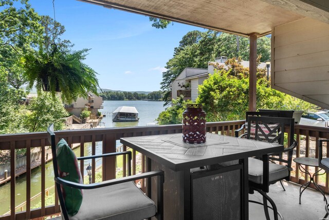 exterior space with a deck with water view and outdoor dining space