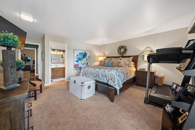 bedroom with light carpet, ensuite bath, and baseboards