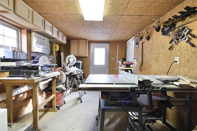 miscellaneous room with unfinished concrete flooring and a workshop area