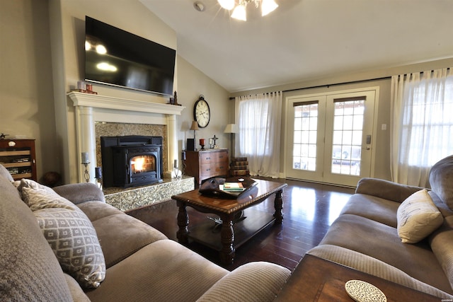 living room featuring vaulted ceiling, dark wood-type flooring, a fireplace, and a healthy amount of sunlight