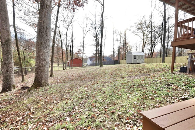 view of yard with an outbuilding, a fenced backyard, and a shed