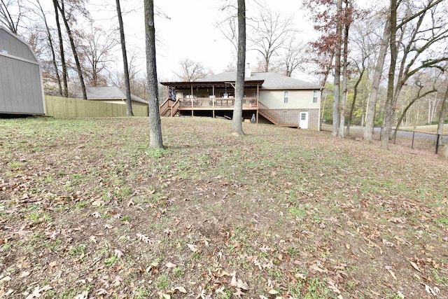 view of yard with a deck, stairway, and fence