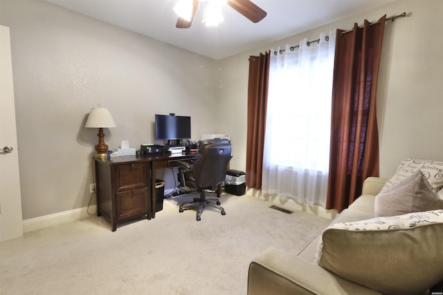 office space with light colored carpet, ceiling fan, and baseboards