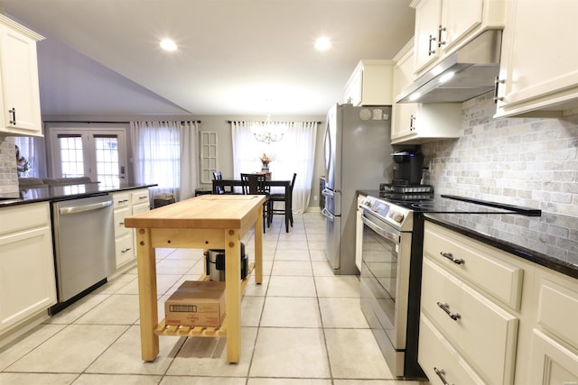 kitchen with under cabinet range hood, tasteful backsplash, light tile patterned floors, and stainless steel appliances