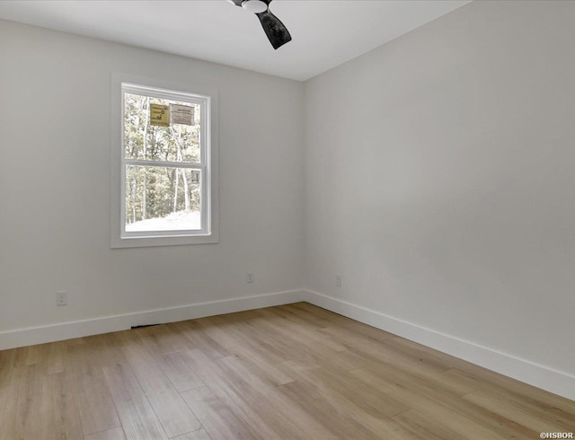 spare room featuring light wood-style floors, ceiling fan, and baseboards