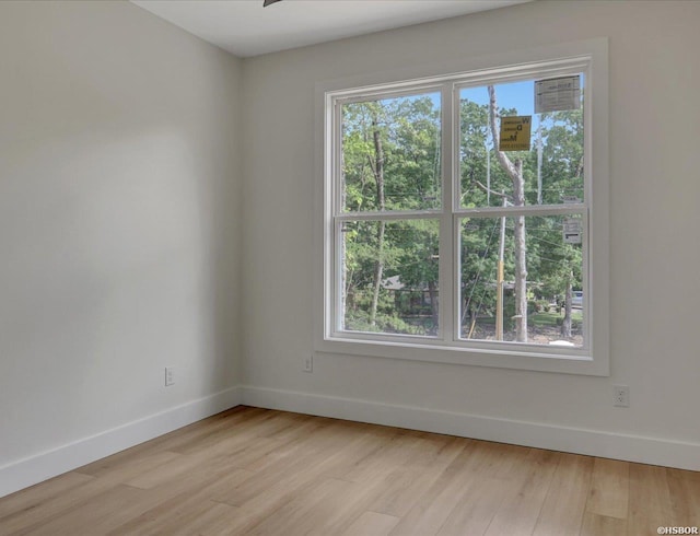 empty room with baseboards and wood finished floors