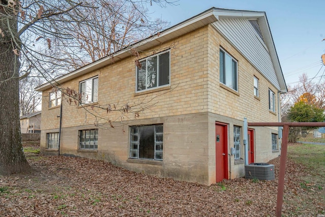 view of side of property featuring central AC and brick siding