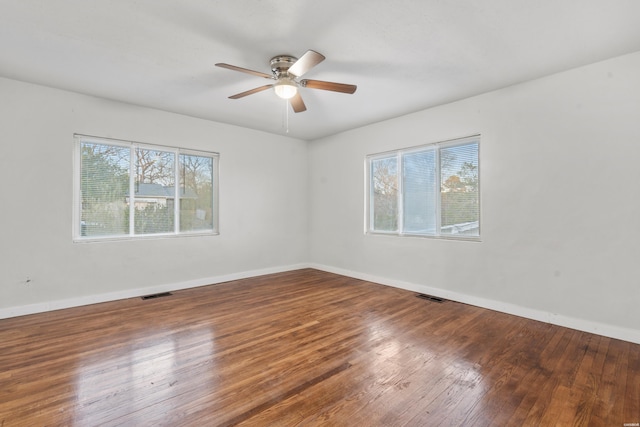 unfurnished room featuring visible vents, plenty of natural light, and hardwood / wood-style floors