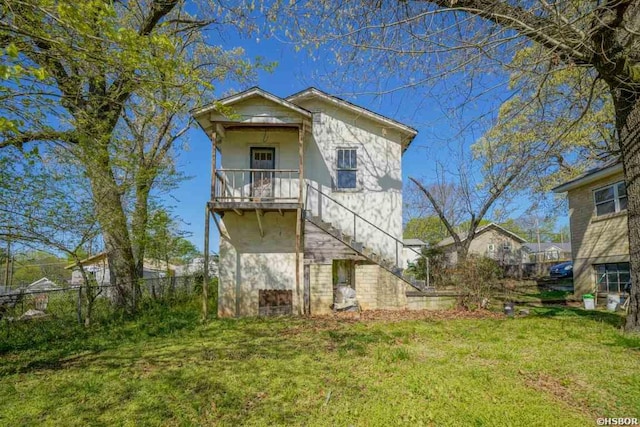 rear view of property with a lawn, stairway, and fence