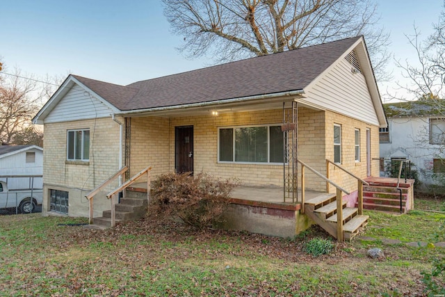 view of front of home with a shingled roof and brick siding