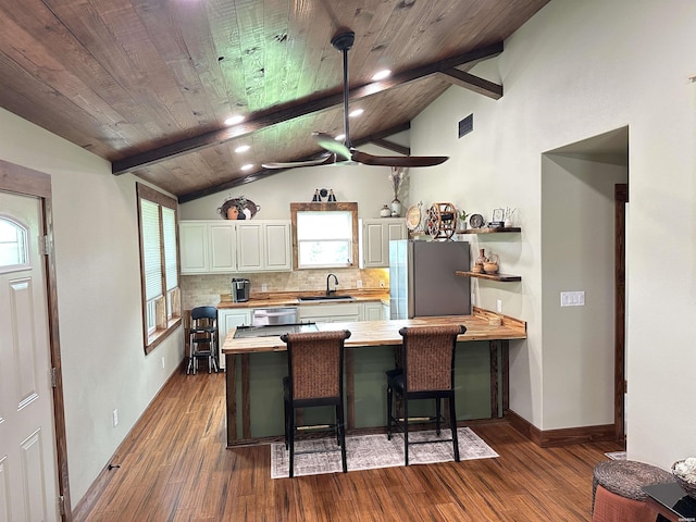324 Quapaw Rd, Bismarck, AR 71929 - kitchen with appliances with stainless steel finishes, a peninsula, dark wood-style flooring, decorative backsplash, and white cabinetry