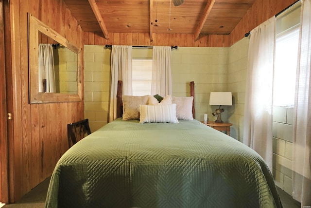 bedroom featuring beamed ceiling, wooden ceiling, and wooden walls