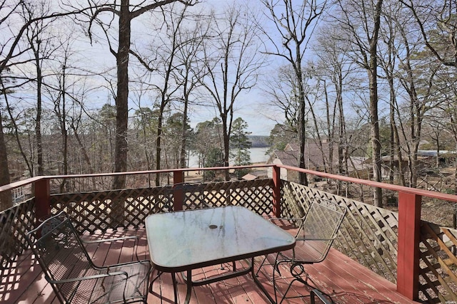 wooden terrace with outdoor dining area and a water view