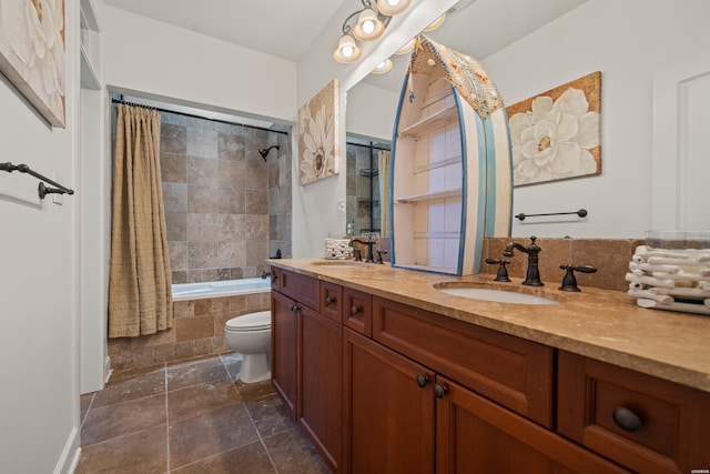 bathroom with double vanity, tiled shower / bath combo, a sink, and toilet