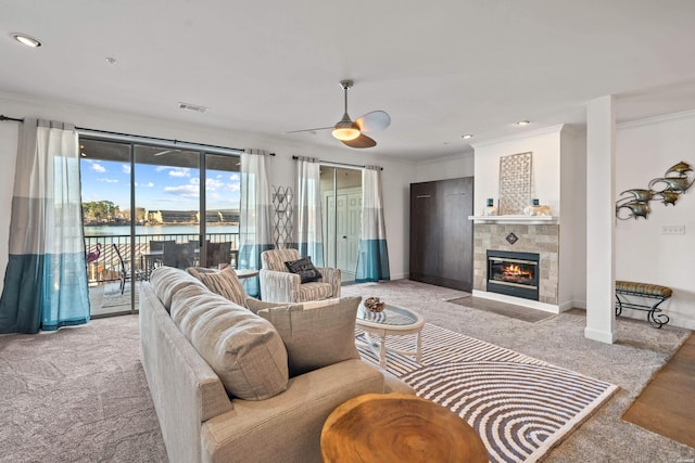 living area featuring light carpet, a water view, ornamental molding, and visible vents