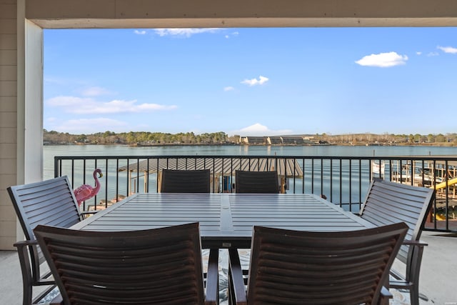 view of patio with a water view, a balcony, and outdoor dining space