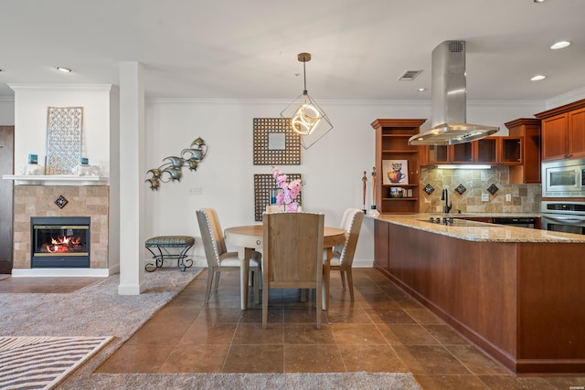 dining space with a tile fireplace, recessed lighting, visible vents, baseboards, and ornamental molding