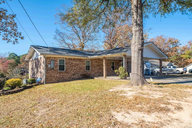 view of front of property featuring a carport, a front yard, concrete driveway, and brick siding