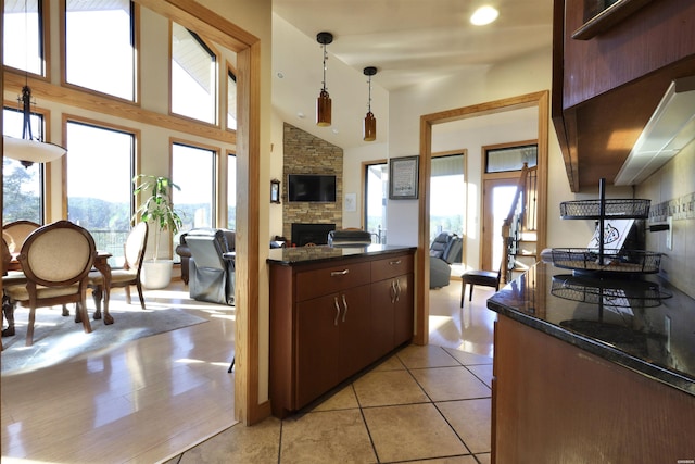 kitchen with open floor plan, a fireplace, a wealth of natural light, and pendant lighting