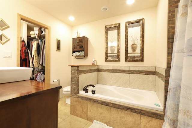 bathroom featuring recessed lighting, a spacious closet, toilet, tile patterned flooring, and a bath