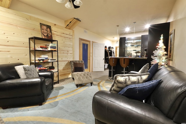 living room featuring wooden walls and visible vents