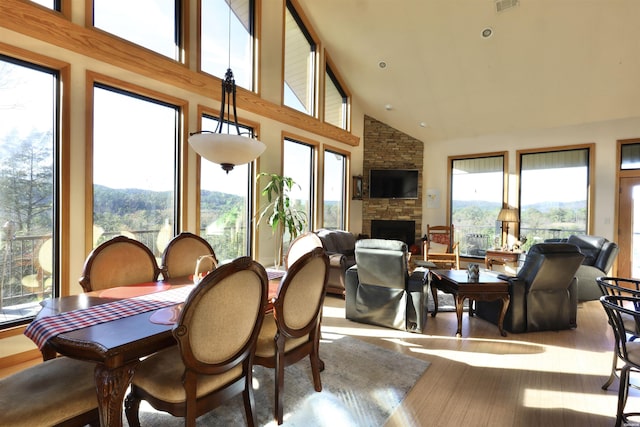 sunroom / solarium featuring vaulted ceiling and a fireplace