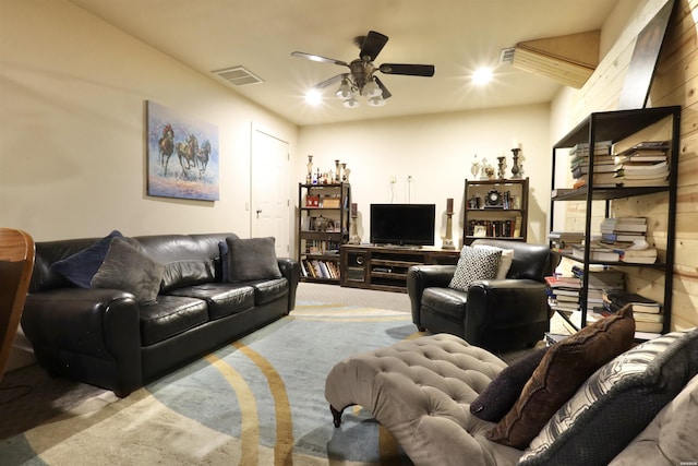 living area with visible vents, ceiling fan, and light carpet