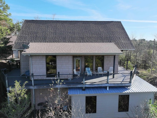 back of house with roof with shingles and a balcony