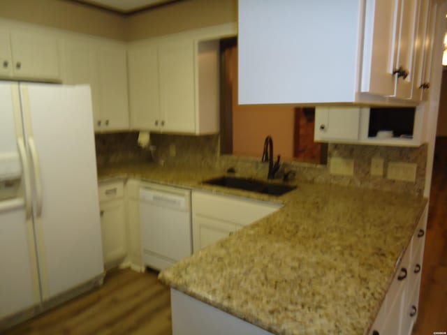 kitchen featuring white appliances, white cabinets, and a sink