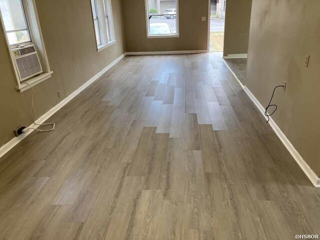 interior space with cooling unit, light wood-style flooring, and baseboards